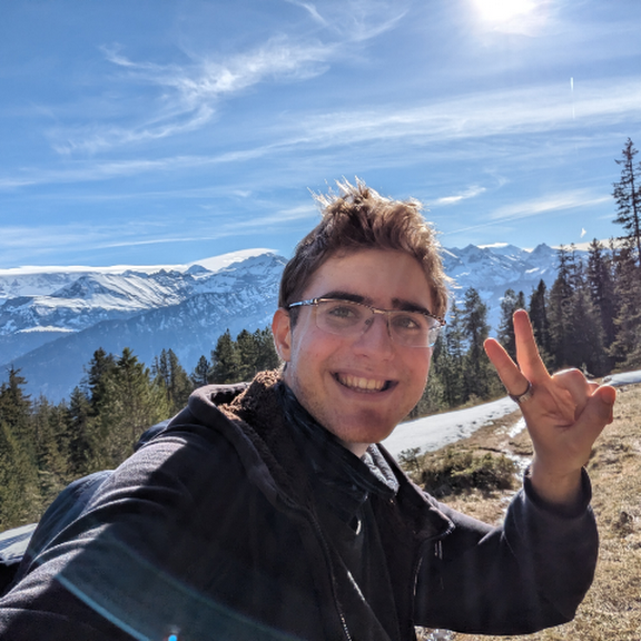 A photo of a handsome guy in front of a waterfall
